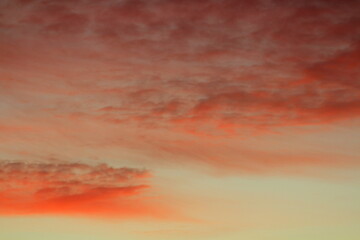 Sun below the horizon and clouds in the fiery dramatic orange sky at sunset or dawn backlit by the sun. Place for text and design