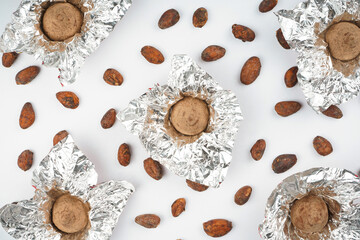 Cocoa bean and chocolate candy truffle pattern on white background. Dessert, recipe, menu concept. Top view, flat lay