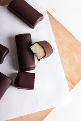Glazed curds in chocolate on a wooden board. Dessert with glazed cheese.