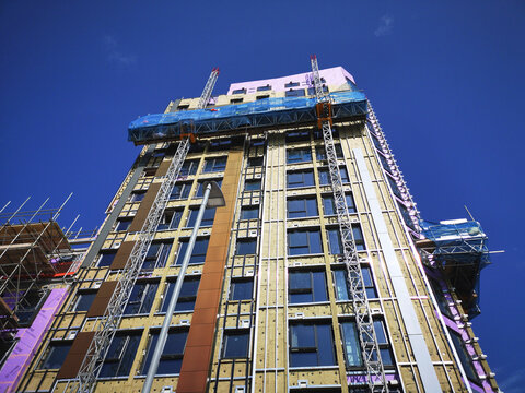New bulid apartment block in the UK. Property development in the city centre with scaffolding and construction equipment.