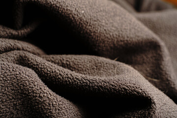 Textile black texture that goes in waves. Dim lights.