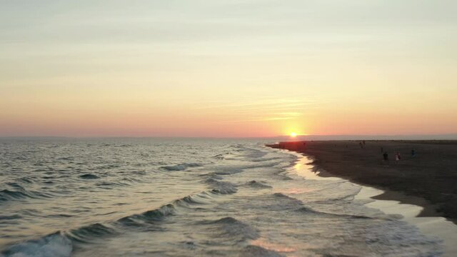 Sunset footage over the mediterranean sea with orange skies.  Flying at a low altitude at Espiguette beach, port camargue