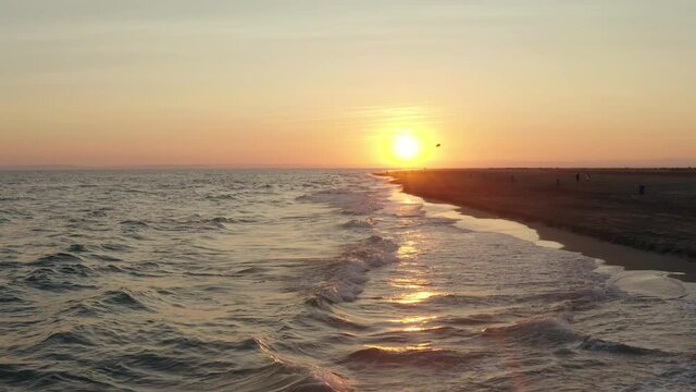 Sunset footage over the mediterranean sea with orange skies.  Flying at a low altitude at Espiguette beach, port camargue