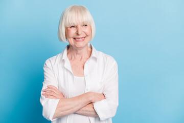 Photo portrait of confident retired woman with crossed hands smiling looking at blank space...