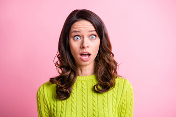 Photo of impressed sad curly young woman dressed green pullover big eyes open mouth isolated pastel pink color background