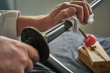 Man cleans blade of traditional Japanese katana sword