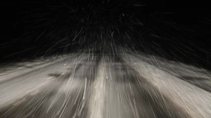 Fototapeten Heavy snowfall, snowstorm on a winter road at night, a car driving on a white highway track with insufficient visibility, a view of the motorway from driver's windglass from inside a moving vehicle © Ilya