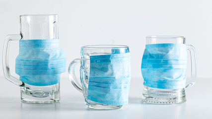 Naklejka premium Three masked beer mugs. Coronavirus restriction in pub