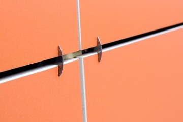 Modern facades of composite panels, view from outside. Element of the facade. Fragment of a ventilated facade made of ceramic tile in orange.