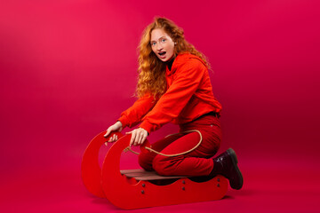 Red-haired girl with a shout sledding on a red background.