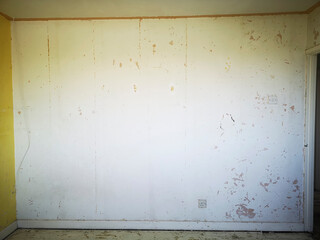 Empty bedroom wall during renovation in a bare room with unpainted walls and bare floorboards awaiting decoration - UK