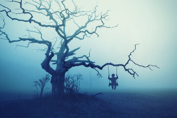 Baum im Nebel mit schaukelnden Kind