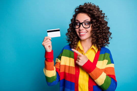 Photo of young curly hair hairstyle girl show point index finger credit card happy smile buy shopping isolated over blue color background