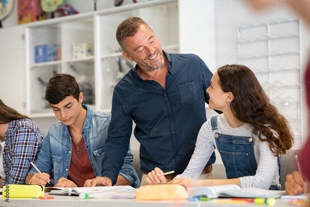 Wall mural Professor helping college students in class during lesson