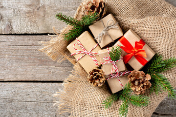 Christmas gift boxes in ecofriendly craft paper. Gifts in a wooden box on a wooden table. Eco-friendly gift packaging