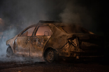 Fototapeta na wymiar Burning police car in the center of city near church during riots caused by new measures of coronavirus in Belgrade, Serbia, 08.07.2020