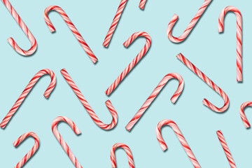 Christmas candy cane flat lay pattern on ice blue background