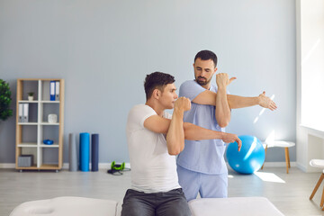 Physiotherapist teaching patient to do cross-body stretch to ease pain and cure shoulder stiffness