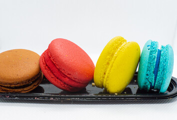 Colorful macaroon cakes. French cupcakes. Soft and colorful French macarons on a black stand