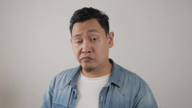 Young asian men wearing jacket mocking with funny face, Sticking out his tongue