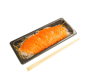 Salmon Sashimi on vegetable slices in black tray, a bamboo chopsticks on side
