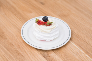 Delicious and beautiful white cake with strawberries and blueberries on a white plate