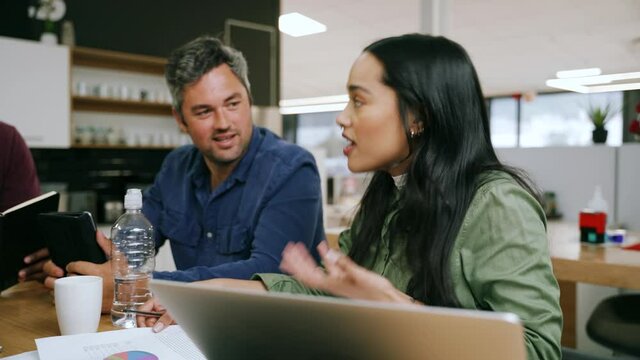 Diverse group of designers brainstorming colour schemes for new logo designs