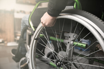 male hand on wheel of wheelchair