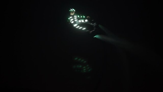 Flyboard, a new sport and show. A flyboarder in a backlit cast shows tricks in the night.