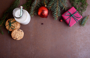 New Year's content with baked cookies, milk, gifts, toy for the Christmas tree, Christmas tree twigs, view from above. Place for text