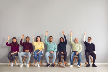 Group of happy diverse people raising hands unanimously voting for suggested idea