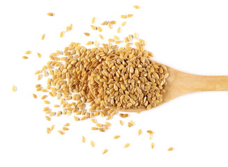 Golden linseed, linen seeds with wooden spoon isolated on white background, top view