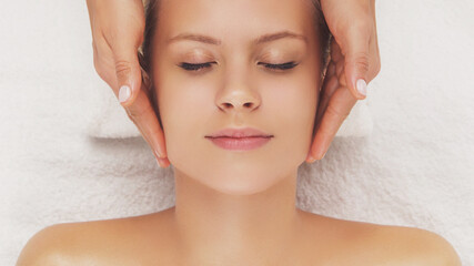 Naklejka premium Young, beautiful and healthy woman in massaging salon. Traditional face massage therapy and skin care.