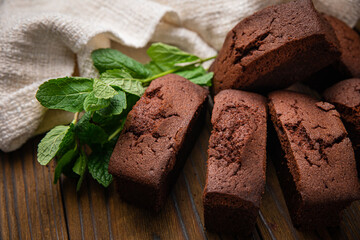 Chocolate cupcakes with mint, cocoa, and cocoa beans on a wooden table
