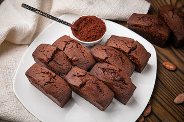 Chocolate cupcakes with mint, cocoa, and cocoa beans on a wooden table
