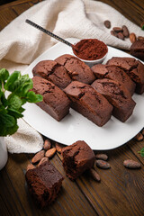 Chocolate cupcakes with mint, cocoa, and cocoa beans on a wooden table
