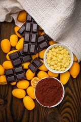 Natural chocolate, cocoa and kumquat on a wooden table
