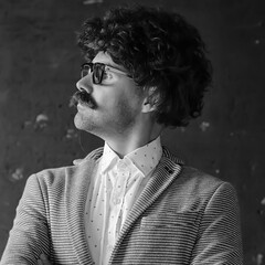 mustachioed man in a classic suit and vintage glasses, curly hipster portrait, long hair