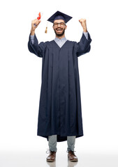 education, graduation and people concept - happy smiling male graduate student in mortar board and bachelor gown with diploma over grey background