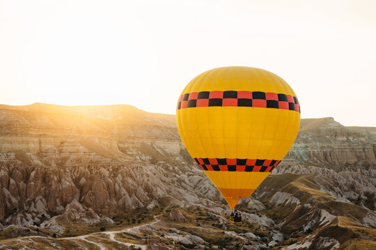 Sunrise in Cappadocia. Flying on air balloon in Gereme, Kapadokya. Large balloon on the background of hills, valleys and sun rays