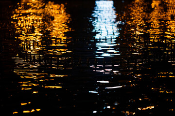 glare of light of the evening city on the water
