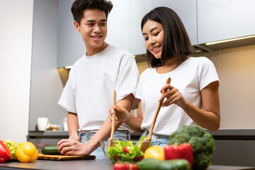 Happy Japanese Spouses Cooking Dinner Together In Modern Kitchen