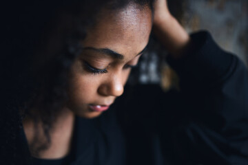 Close-up portrait of sad mixed-race teenager girl standing, bullying concept.