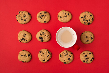 Yummy cookies with cup of fresh aromatic coffee standing in flatlay rows isolated bright color red background frame