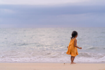 Fototapeta na wymiar Active Young girl playing at the beach at Dusk.