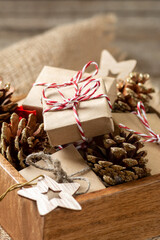 Christmas gift boxes in eco-friendly craft paper. Gifts in a wooden box on a wooden table. Eco-friendly gift packaging