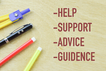 Top view of colors, pen and compass geometry on wooden background written with text HELP SUPPORT ADVICE GUIDANCE. Business and education concept.