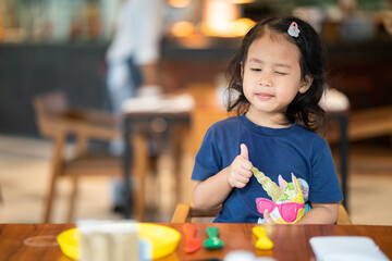 Happy little girl sitting on wooden table.