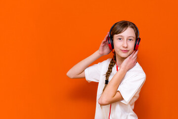 Attractive 12s girl in white t-shirt listens to music on headphones closeup