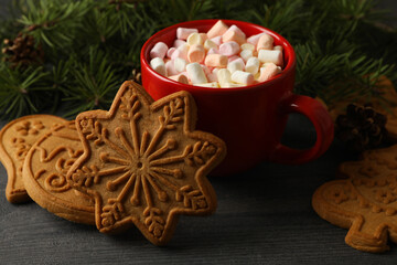 Cup with marshmallow, Christmas cookies and pine branches on table